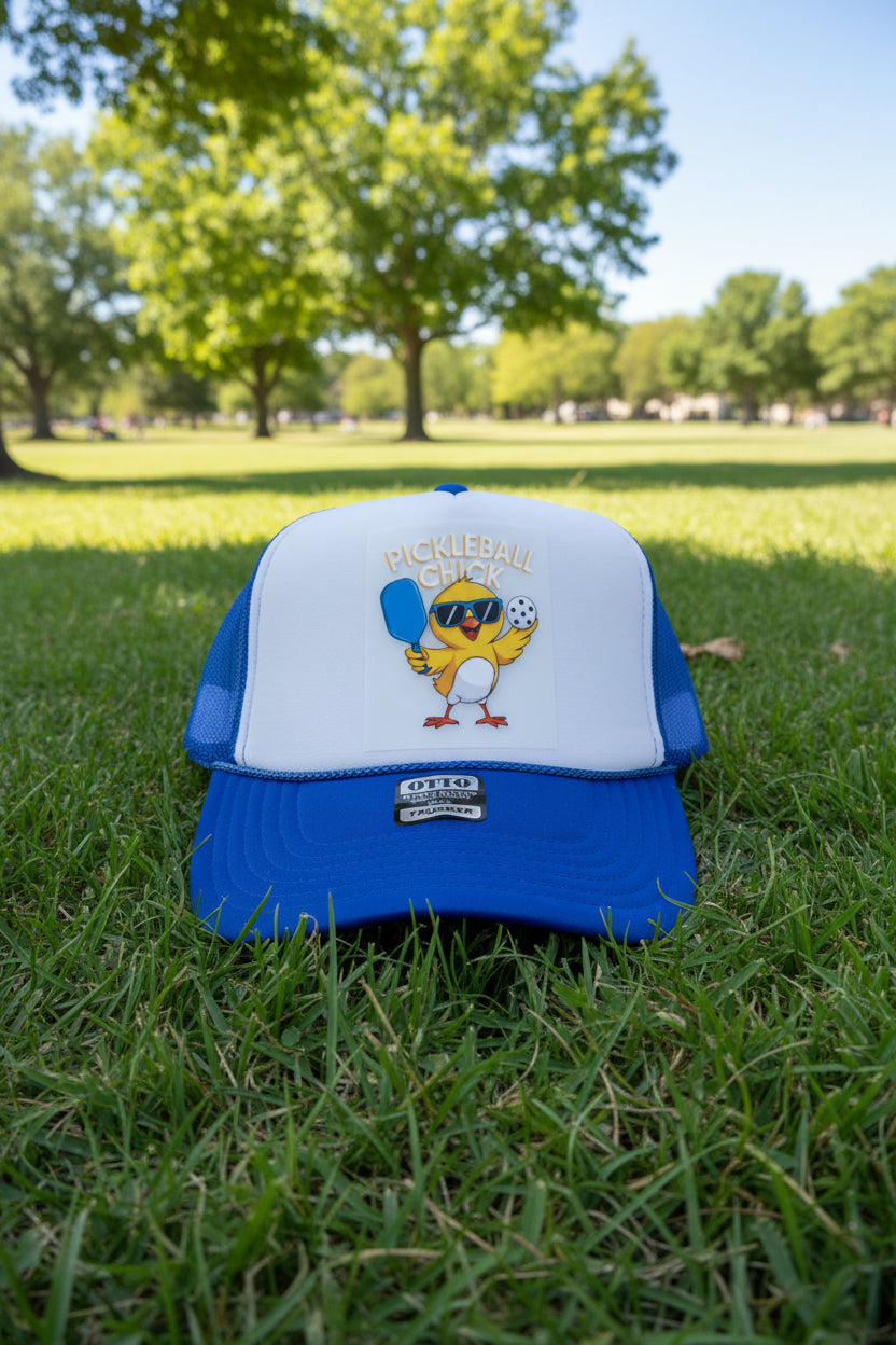 A blue and white trucker hat featuring a 'Pickleball Chick' graphic on the front panel, with a visible OTTO brand patch on the brim, set on a wooden surface.