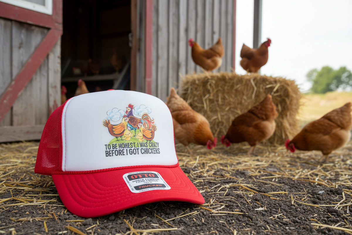A red and white trucker hat with a cartoon chicken graphic and the text 'TO BE HONEST I WAS CRAZY BEFORE I GOT CHICKENS' on the front. The hat has a red brim, white front panel, and red mesh back, and features an Otto Trucker sticker on the brim.