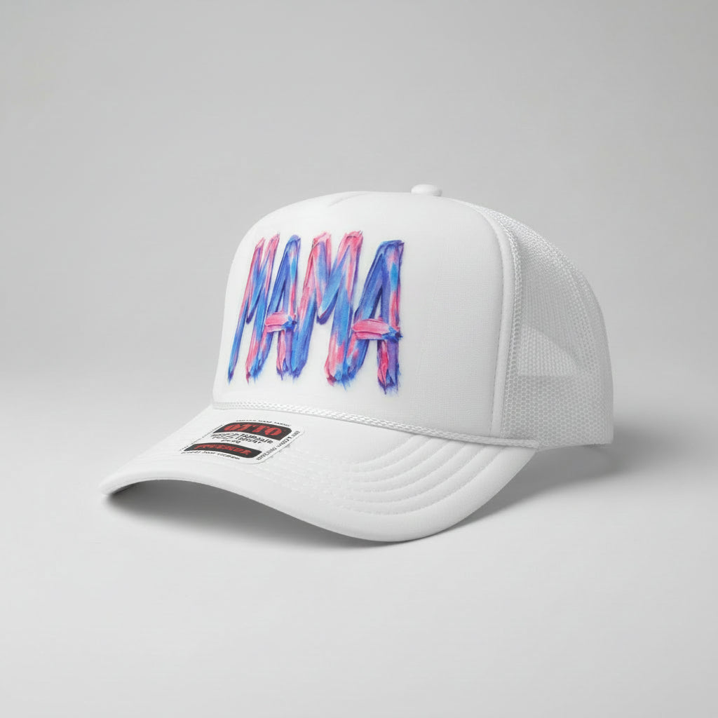 A white trucker hat with a colorful 'MAMA' graphic on the front panel, featuring blue and pink paint-stroke lettering. The brim has a visible 'OTTO' brand sticker.