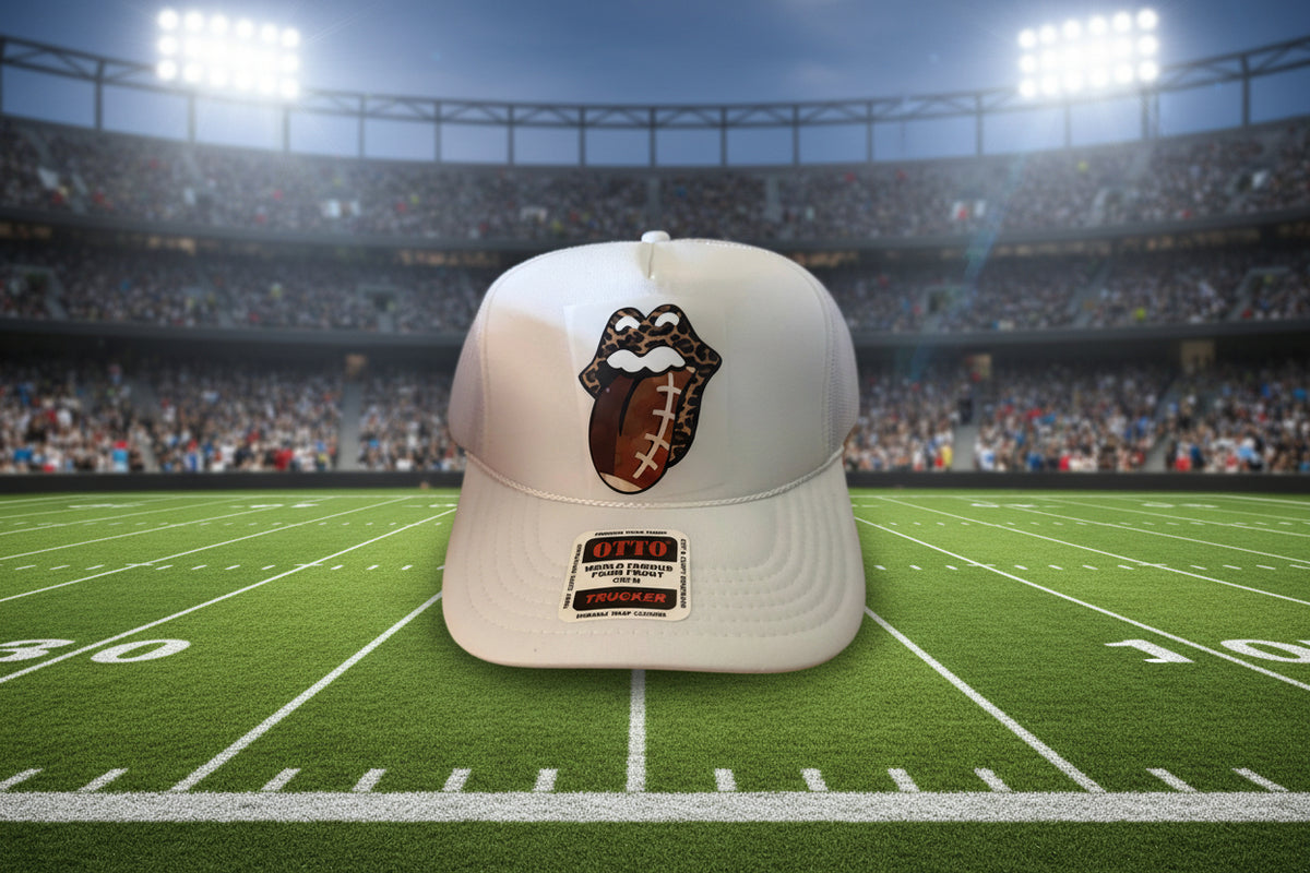 A white trucker-style cap featuring a custom football-themed Rolling Stones tongue logo on the front.