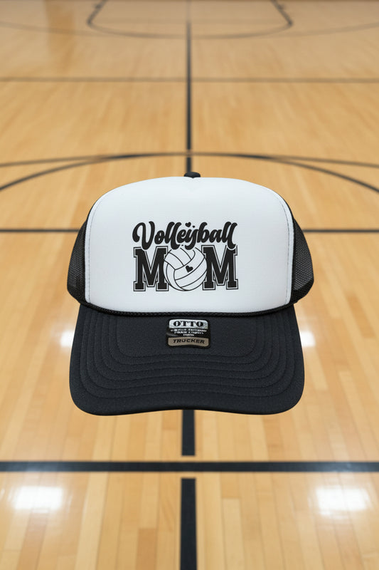 A black and white trucker hat with 'Volleyball MOM' printed on the front.