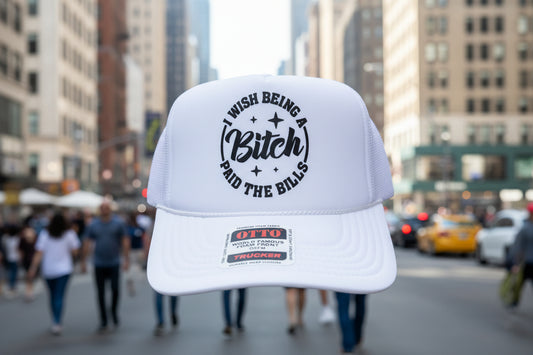 A white trucker hat with a black graphic print on the front panel reading 'WISH BEING A Bitch I PAID THE BILLS' 