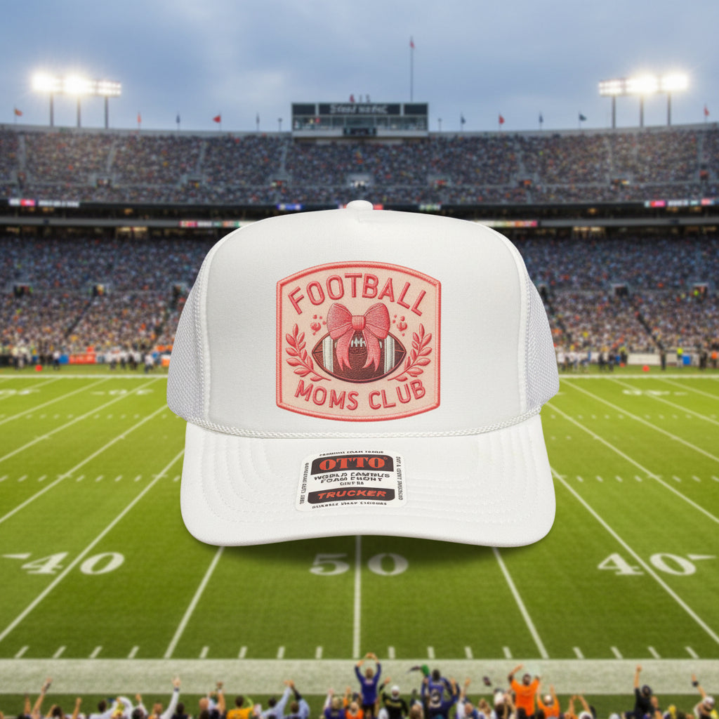 A white trucker hat with a pink and red 'Football Moms Club' patch on the front, featuring a foam front panel and snapback closure.