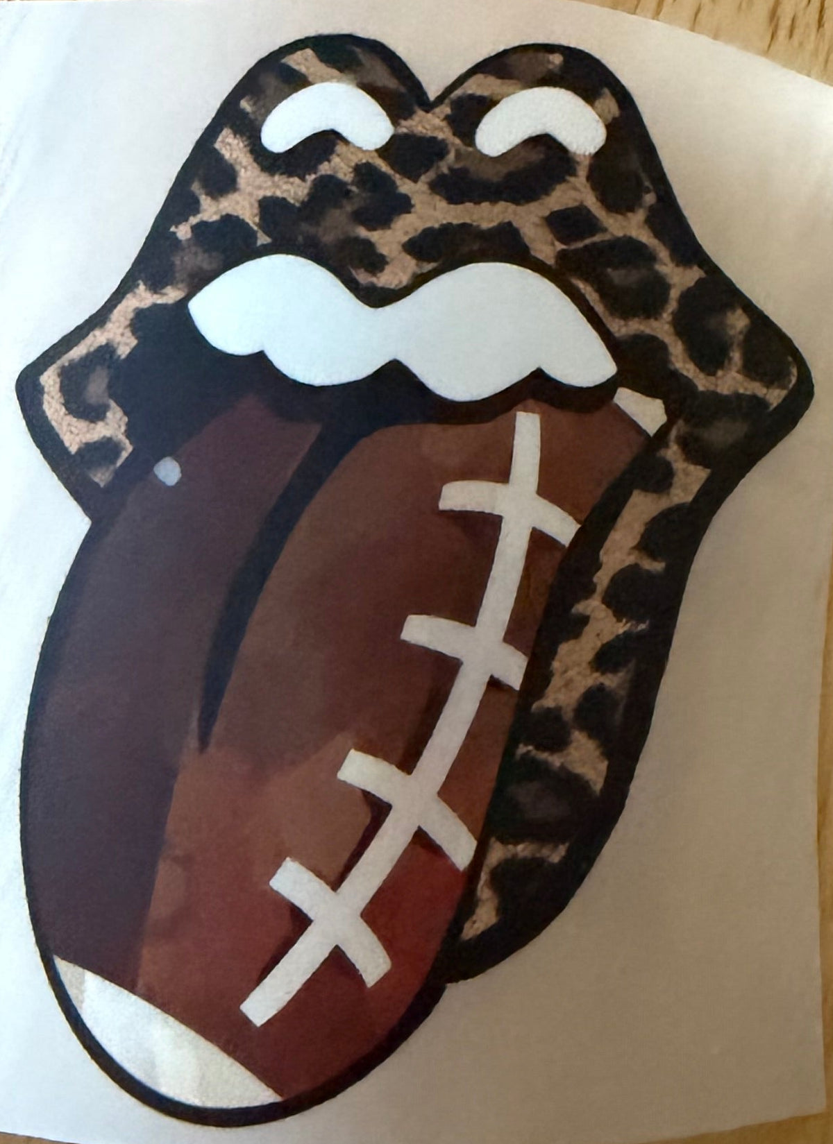 A DTF hat print featuring the Rolling Stones logo with a football motif.