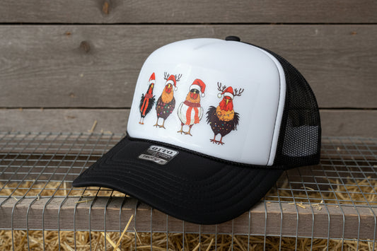 A black and white trucker hat with a custom graphic of four cartoon chickens wearing Santa hats and holiday outfits on the front panel. The hat has a black brim and black mesh back, and an Otto Trucker label is visible on the brim.