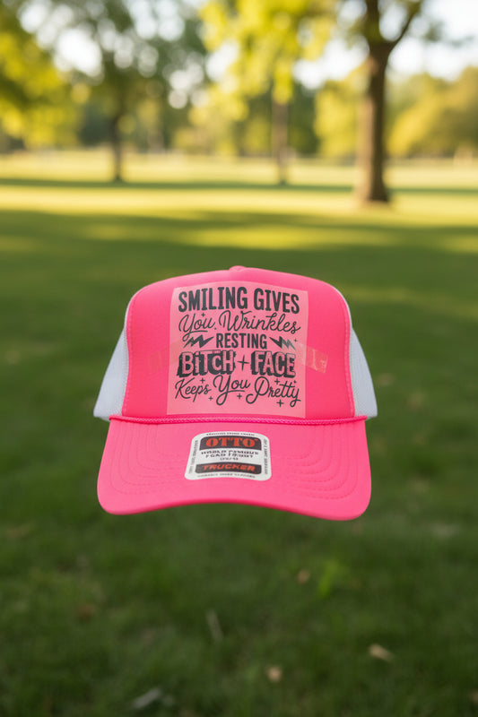 A bright pink trucker hat with a DTF print on the front panel.