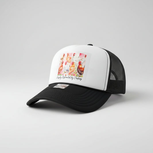 A black and white trucker hat with a graphic print of colorful chickens on the front panel, resting on a rustic wooden surface. The hat features a white front panel with a black mesh back and a black brim, with a visible 'Otto' brand patch on the brim.