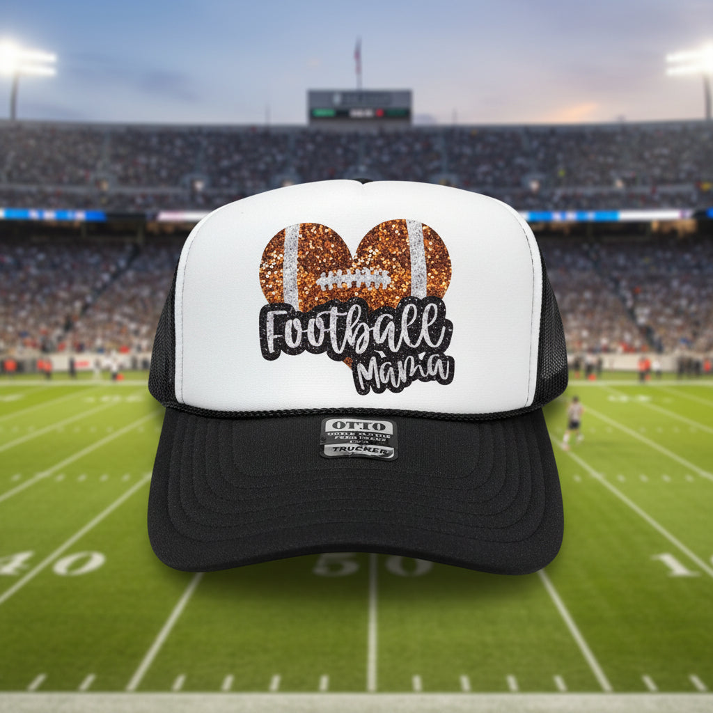 A black and white trucker hat with a custom 'Football Mama' graphic on the front panel. The graphic features two glittery brown footballs and black script text.