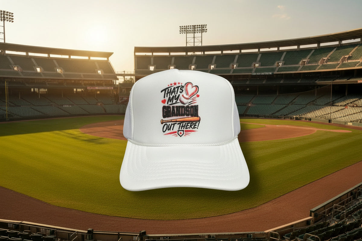 A white trucker hat with a custom graphic on the front panel that reads 'THAT'S MY GRANDSON OUT THERE!' with a heart and baseball design. The brim features a visible Otto Trucker snap closure label.