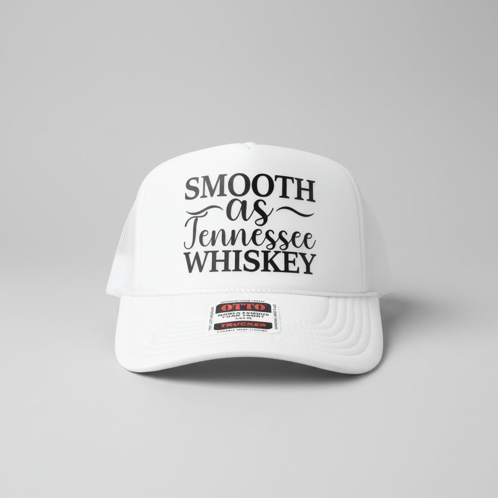 A white foam trucker hat with black text reading 'SMOOTH as Tennessee WHISKEY' on the front panel, photographed on a wooden surface. A visible patch on the brim reads Otto Trucker.