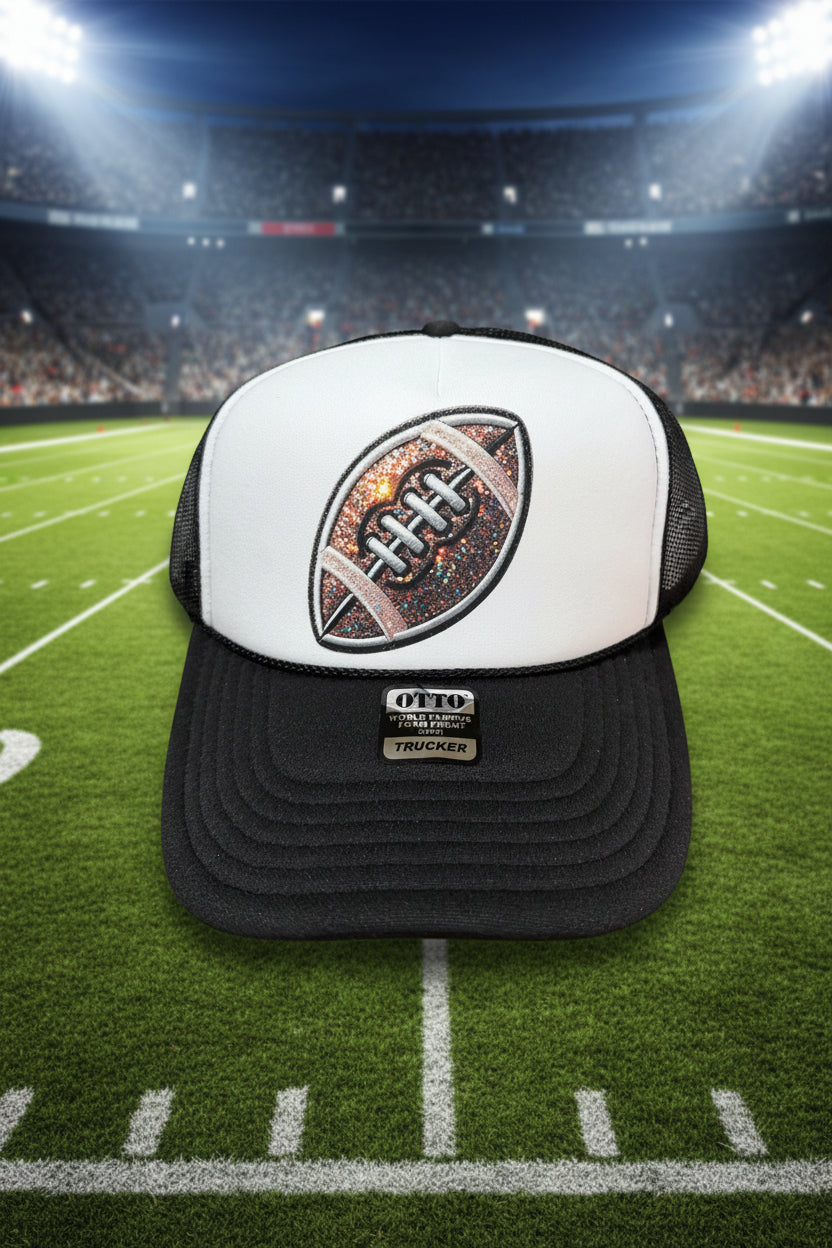 A black and white trucker hat with a glittery football patch on the front. The hat has a white front panel, black mesh back, and a black brim with a visible 'OTTO' brand patch.