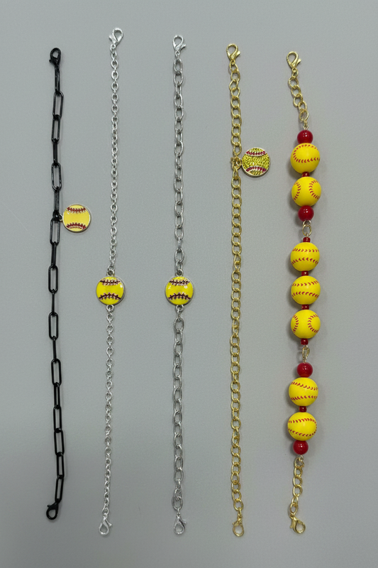 Four different styles of softball-themed chain accessories laid out vertically on a neutral gray background, including black, silver, and gold chains with yellow softball charms and red beads.