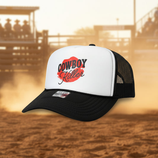 A black and white trucker hat with a white front panel and black mesh sides. The front panel features a graphic with a red lipstick mark and the words 'COWBOY Killer' in black.