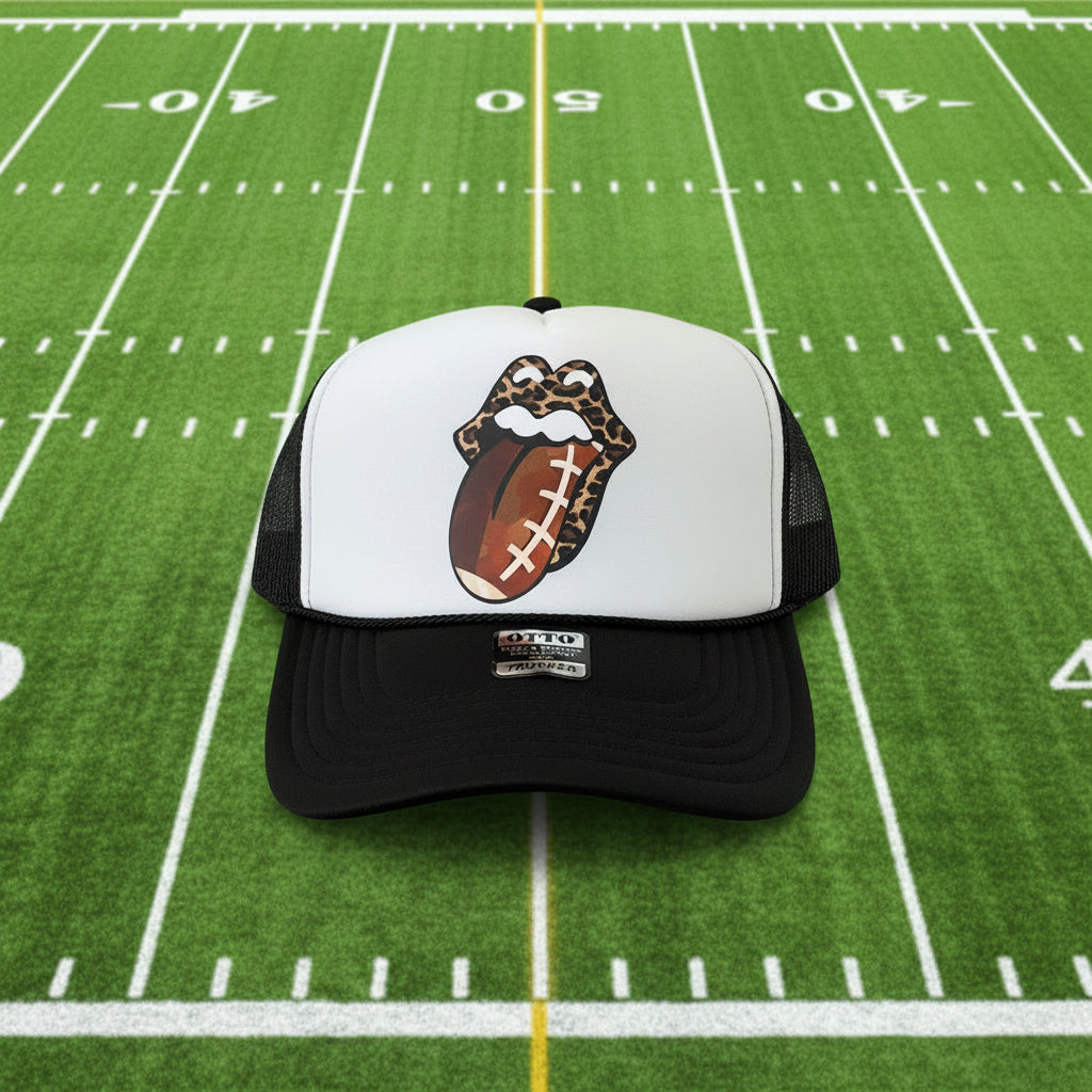 A black and white trucker hat featuring a custom graphic of the Rolling Stones lips with a football pattern. 