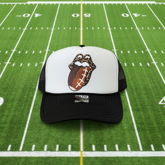A black and white trucker hat featuring a custom graphic of the Rolling Stones lips with a football pattern. 