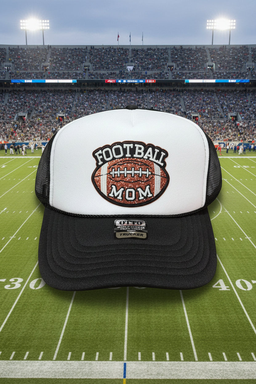 A black and white trucker hat with a glittery football patch on the front that reads 'FOOTBALL MOM'.