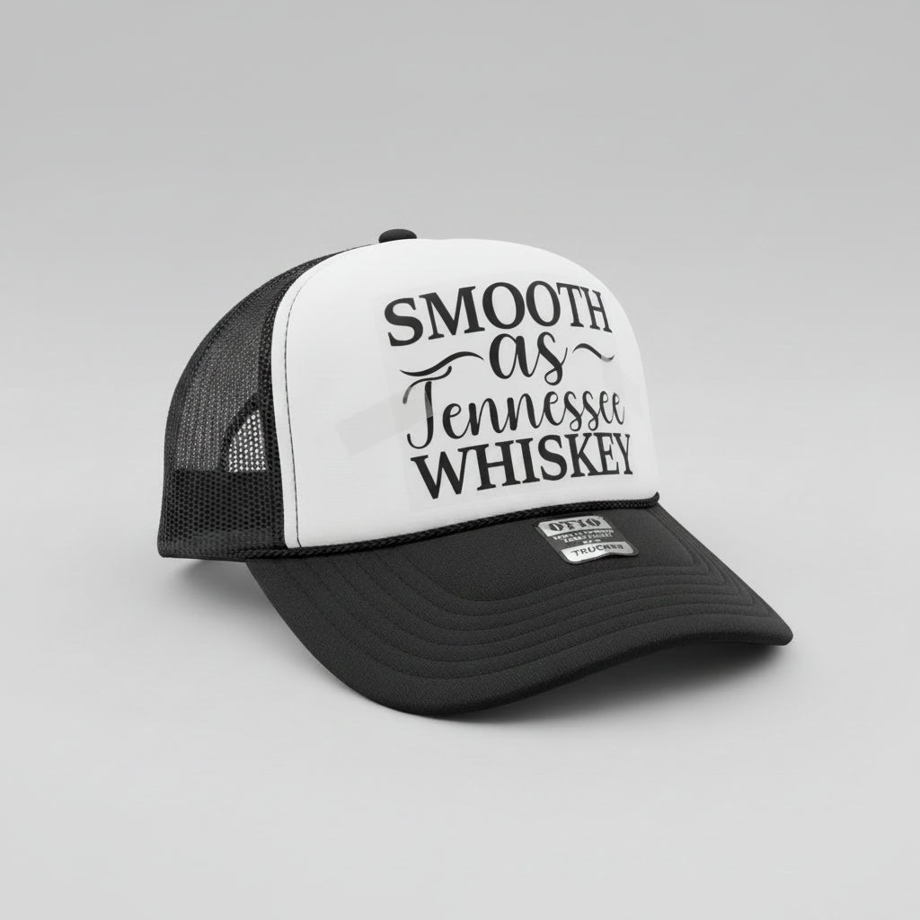 A black and white trucker hat with the phrase 'SMOOTH as Tennessee WHISKEY' printed on the front panel. The hat has a black brim, black mesh back, and a silver-tone metal badge on the front of the brim that reads 'OTTO WORLD FAME TRUCKER'.