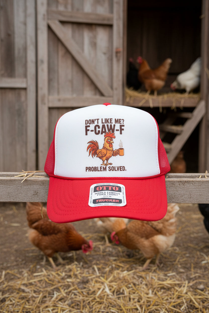 A red and white trucker hat with a printed graphic on the front panel. The graphic features the text 'DON'T LIKE ME? F-CAW-F PROBLEM SOLVED.