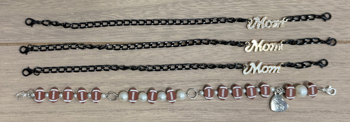 Hat chains with 'Mom' text and football/bead designs, displayed on a light wood background.